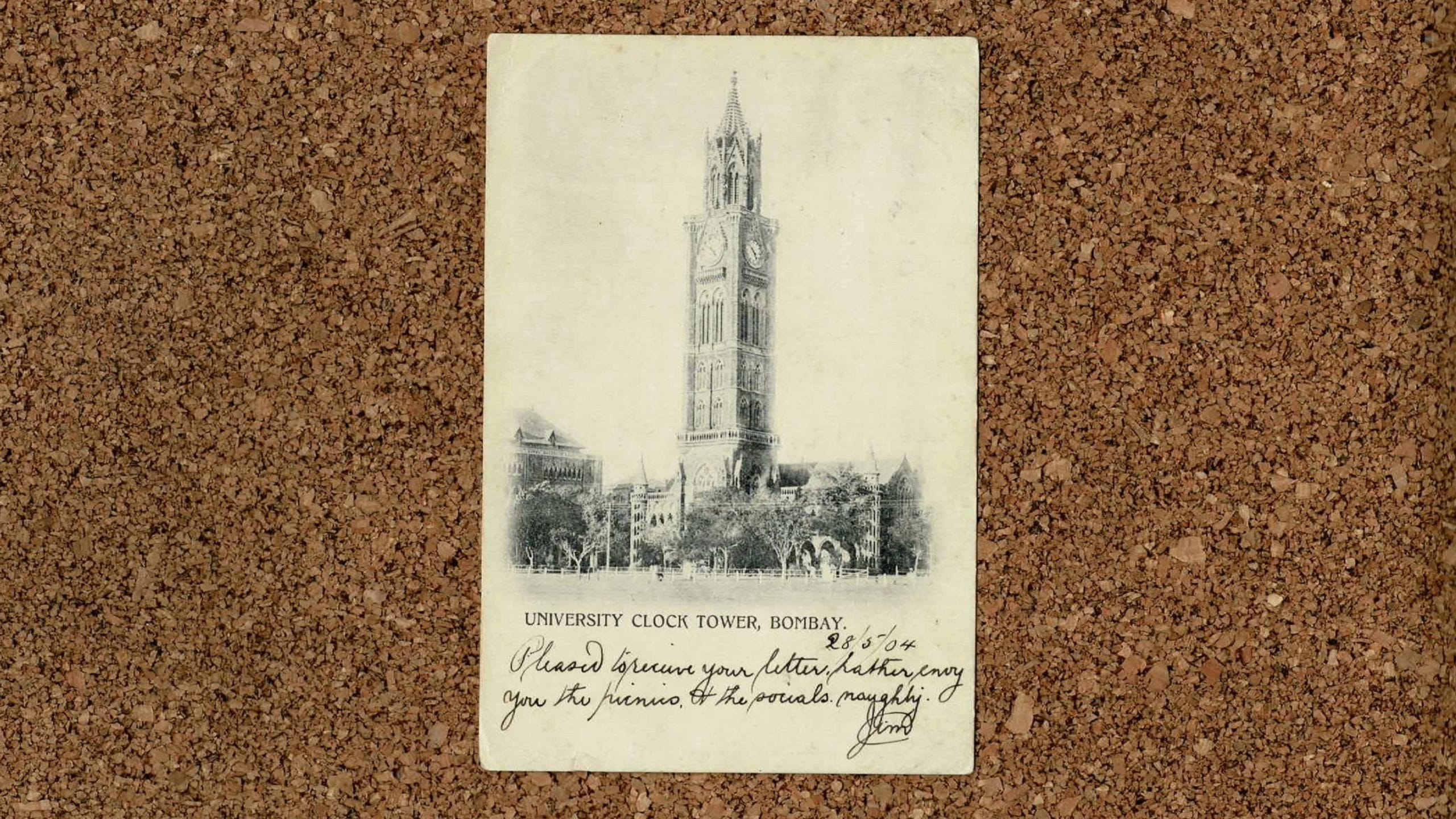 Image of a postcard of the Rajabai Tower Mumbai on a cork background