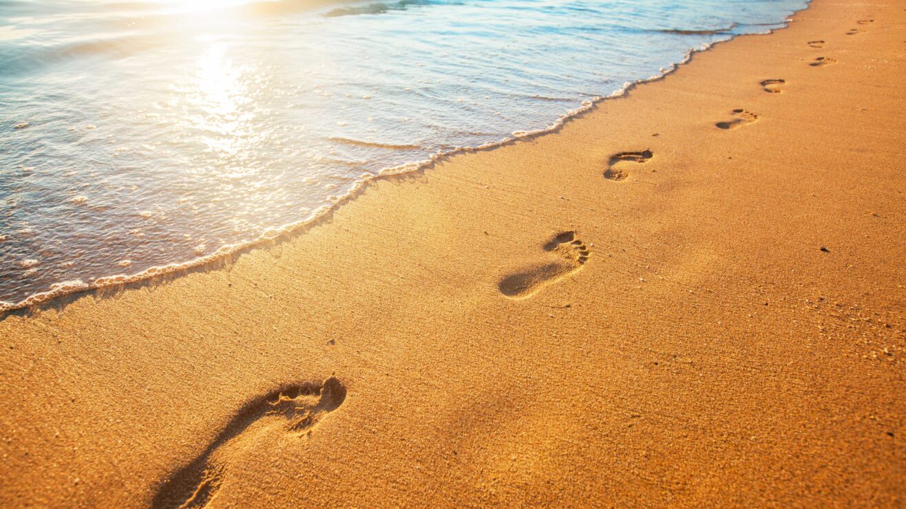 Beach,,Wave,And,Footprints,At,Sunset,Time