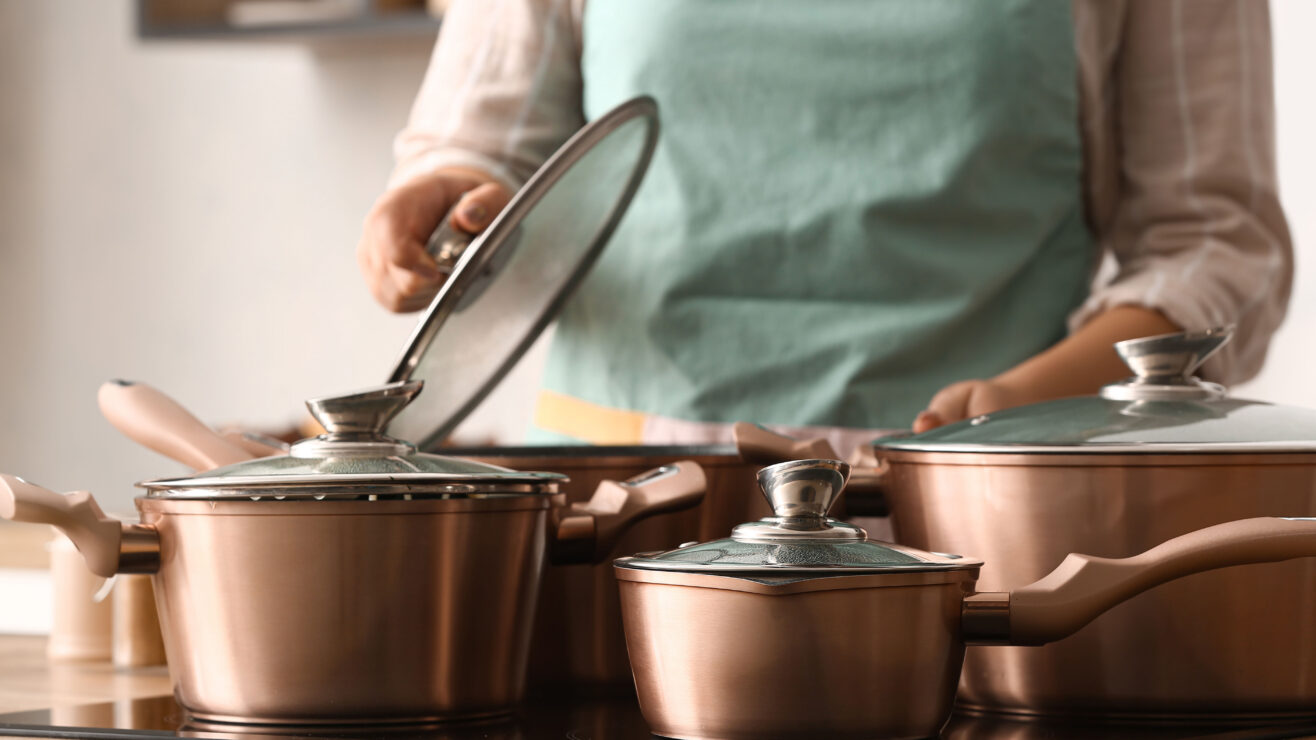 Woman,With,Copper,Pots,Cooking,In,Kitchen,,Closeup