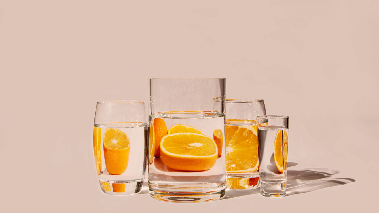 Oranges,Behind,Glass,Vessels,Filled,With,Water.,Distorted,Reflection.