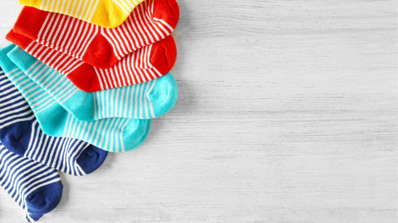 Baby,Socks,On,Wooden,Background