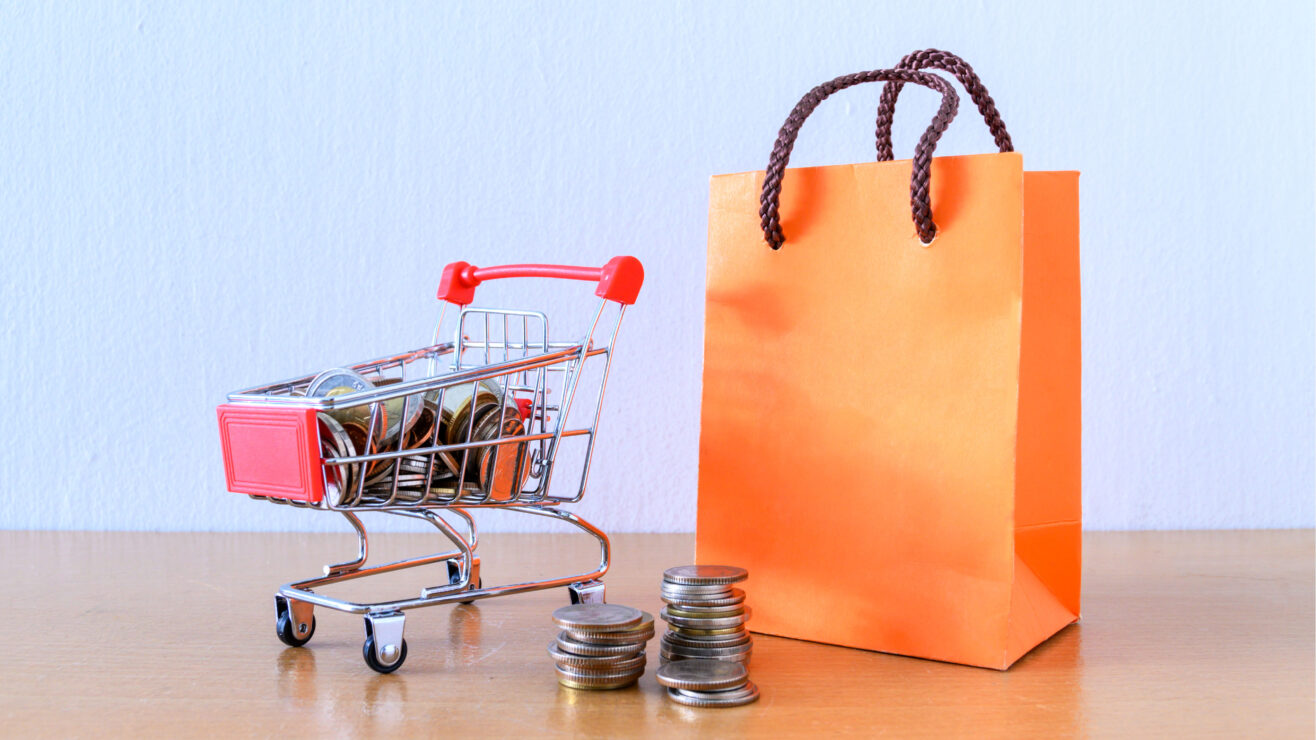 Cart,Supermarket,And,Orange,Paper,Bag,On,Wood,Table.,Shopping