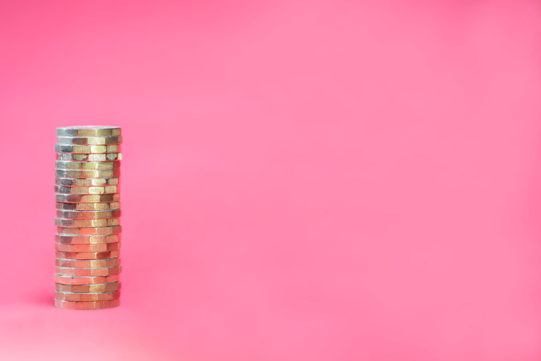 Stacked,Pound,Coins,On,Pink,Background,With,Negative,Space,For