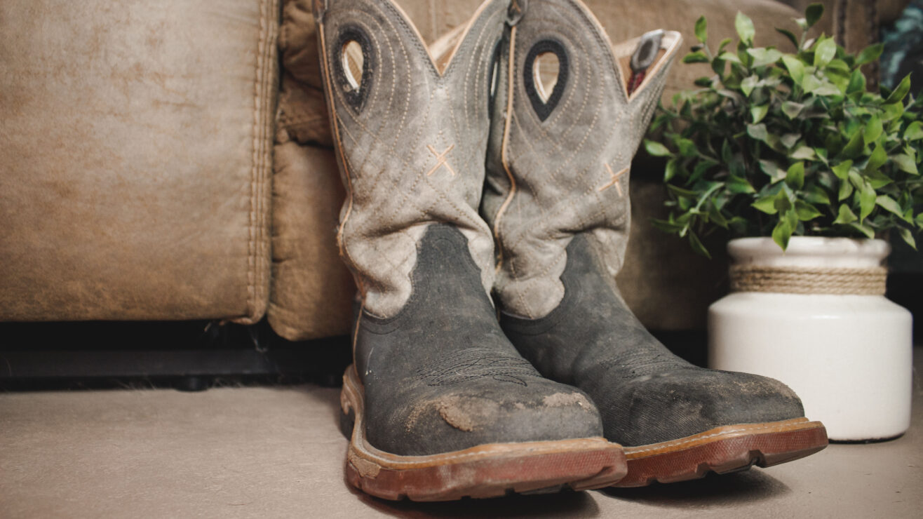 Weathered,,Muddy,Boots,By,A,Timeworn,Couch,Evoke,Rustic,Warmth