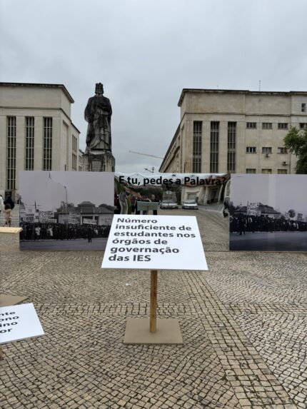 Image of a placard with "universities don't have enough students on governing bodies" written in Portuguese at the University of Coimbra