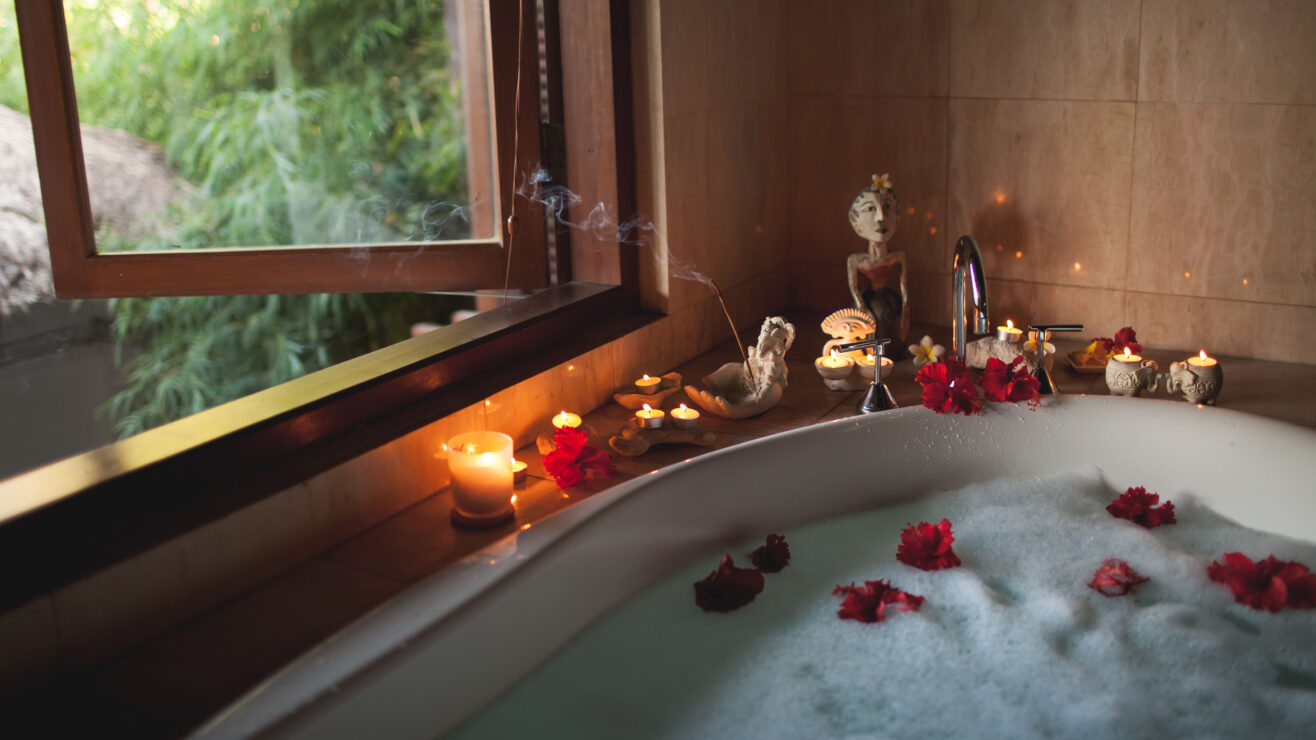 Large,Filled,Bath,With,Foam,And,Flowers.,Romantic,Atmosphere,,Burning